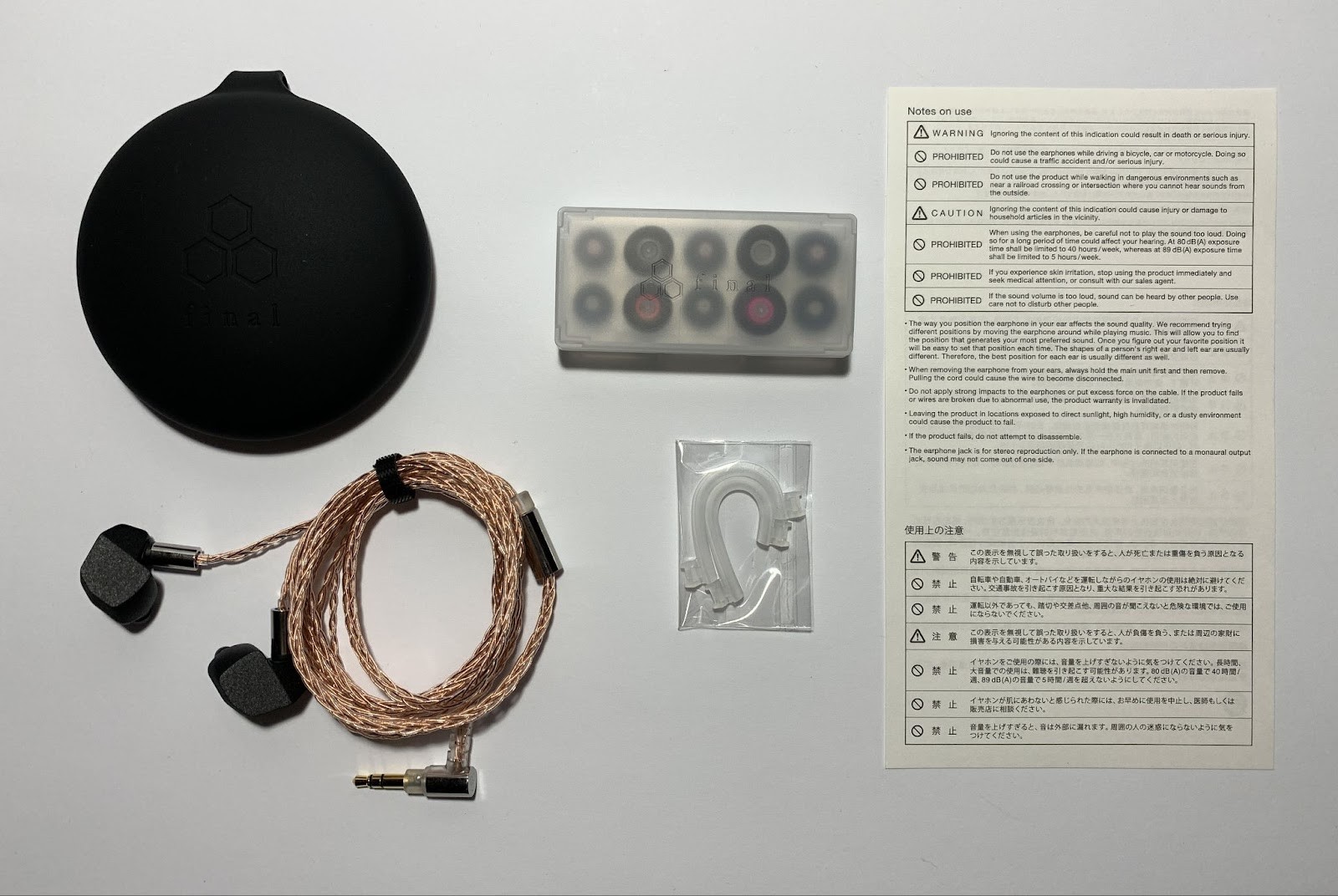 Opening the box, on top in a foam bed is a silicone case, additionally packed in a cellophane bag. Inside are the headphones, already connected to the cable, but without ear pads.Each earphone and cable plug are wrapped in small cellophane bags and secured with tape. 